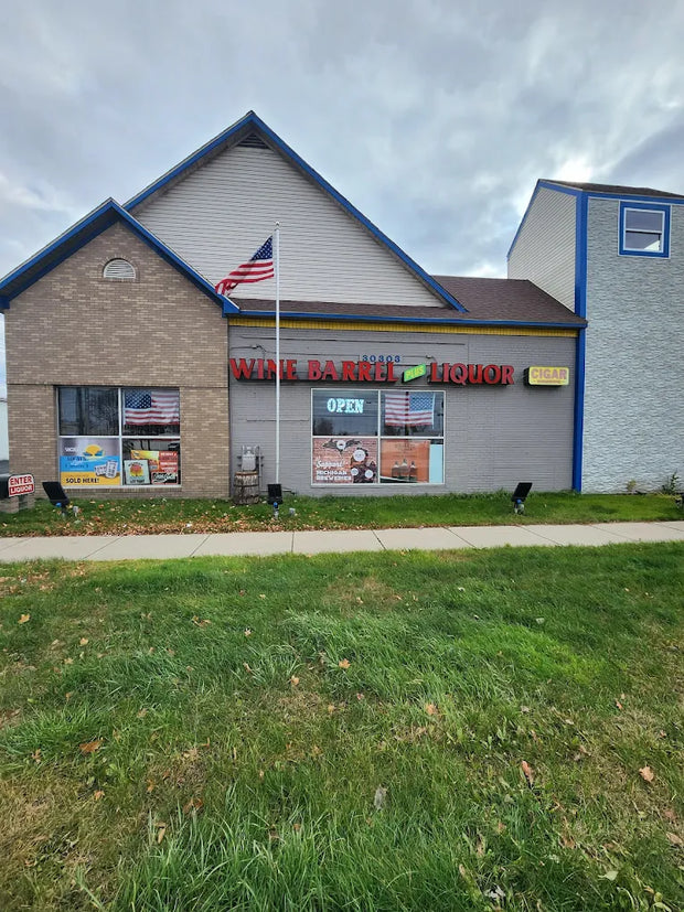 Storefront with a sign for wine, beer, and liquor on a cloudy day.