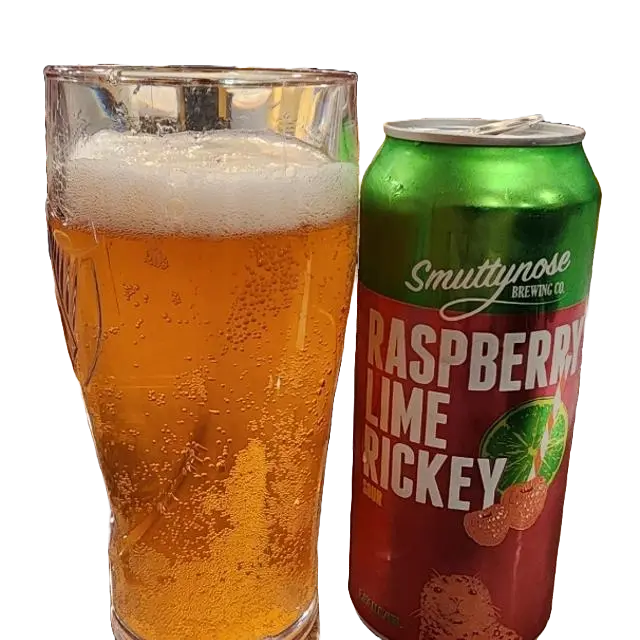 Pint glass filled with beer next to a can of Smuttynose Raspberry Lime Rickey on a white background